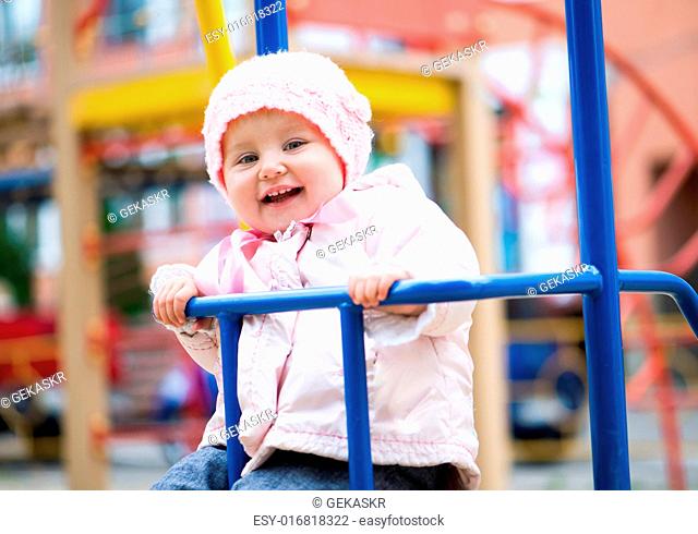 smiling little baby swinging at the park