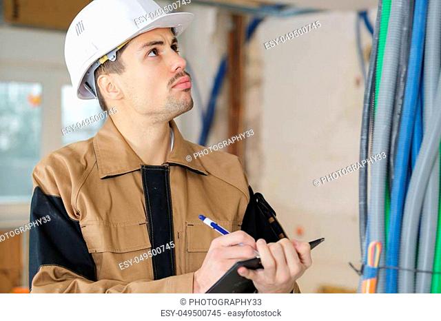 smart pensive builder thinking about something indoors