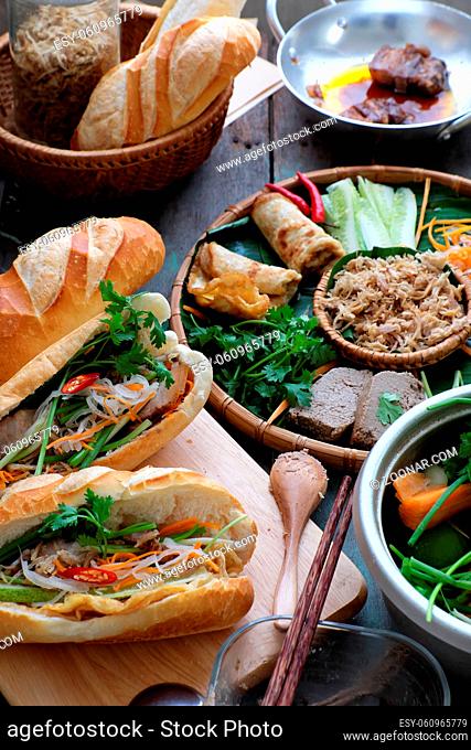 Famous Vietnamese food is banh mi thit, popular street food from bread stuffed with raw material: pork, ham, pate, egg and fresh herbs as scallions, coriander