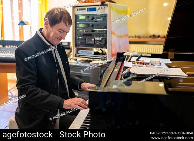 19 December 2023, Bavaria, Geiselhöring: Hans-Jürgen Buchner from the music group Haindling sits at a grand piano in his home in Haindling