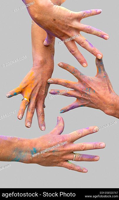 female hands covered with colorful paint splatters in light grey back