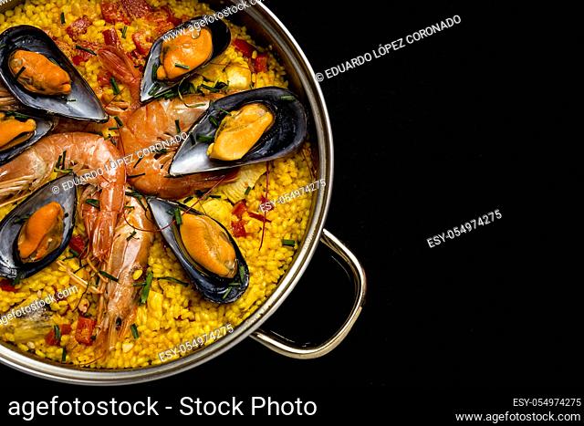 Traditional rice in paella with fish and meat. Typical Spanish