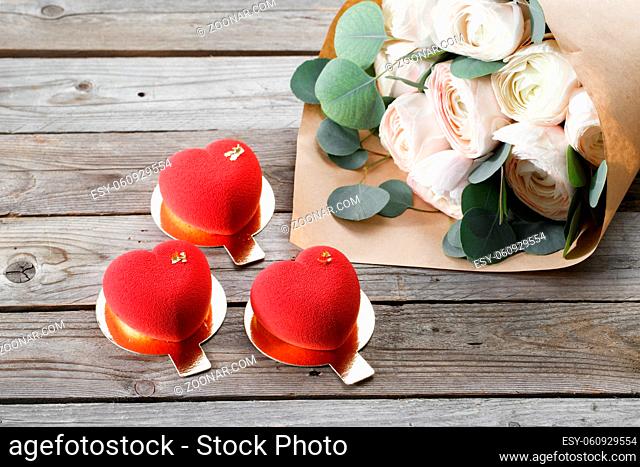 Red heart cacke desserts and buttercups on wooden background. dessert for breakfast on Valentine's Day