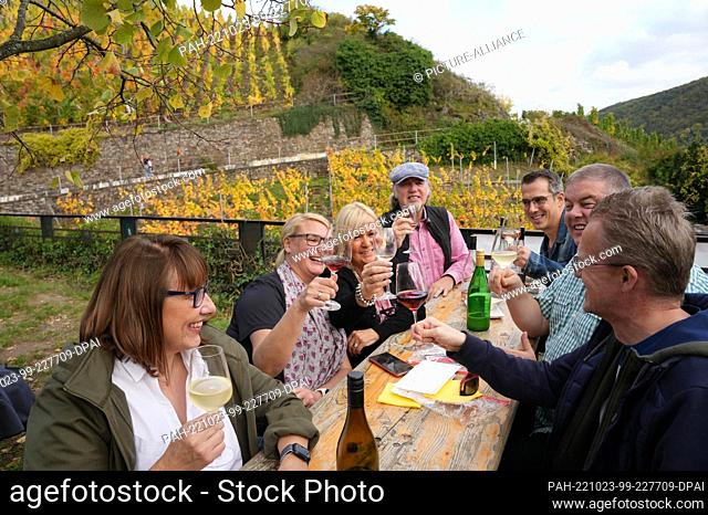 22 October 2022, Rhineland-Palatinate, Dernau: Hikers drink a glass of wine during a break above the village. After the Ahr flood with at least 134 deaths in...