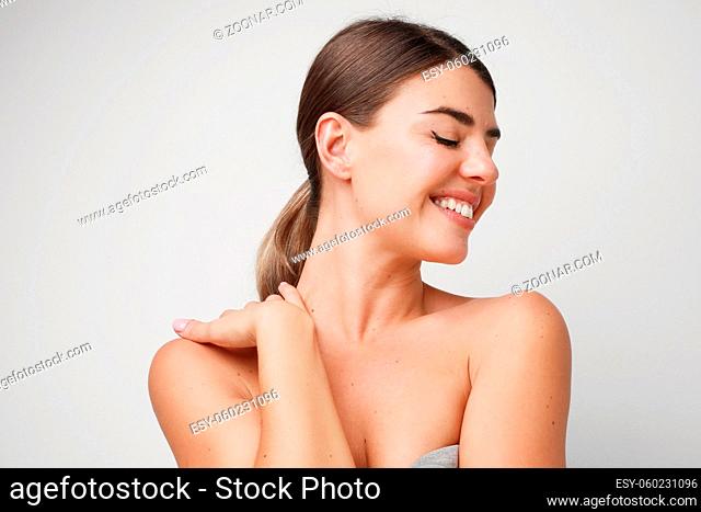 Close-up portrait of young attractive woman posing in the studio. Isolates on white wall. High quality photo