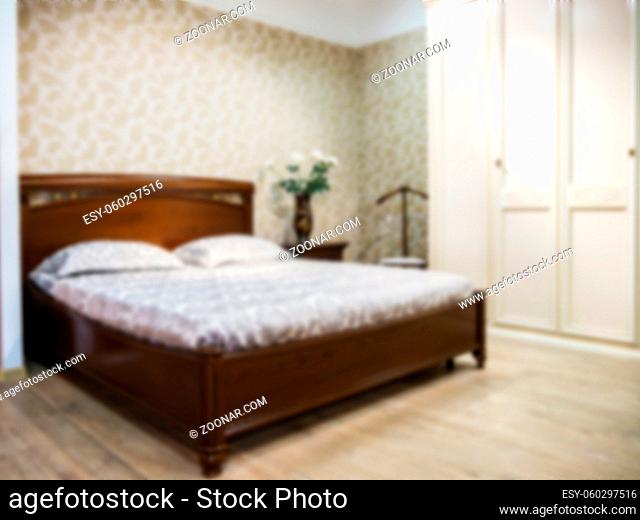 Abstract blur Interior of modern comfortable hotel bedroom. Blurred bedroom with dark brown wooden bed