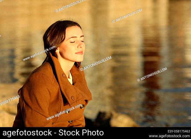Relaxed woman in winter breathing fresh air on the beach