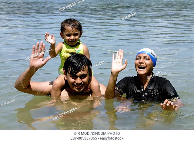 Parents and two year old baby girl enjoying swimming in Wandoor beach on South Andaman Islands ; Bay of Bengal ; India MR 736J 736K 736L  2008