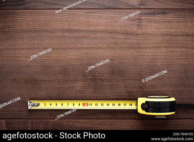 tape measure on the brown wooden background