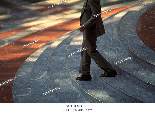Businessman walking down stairs, side view, New York City, NY, USA