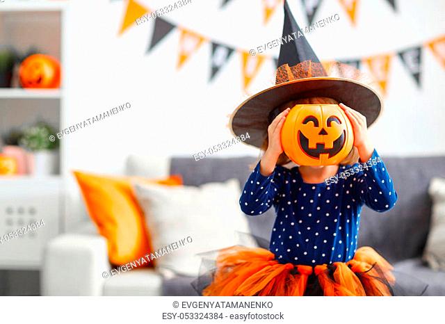 happy laughing child girl in witch costume to halloween