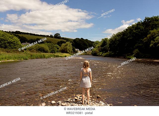 Woman standing near stream at countryside