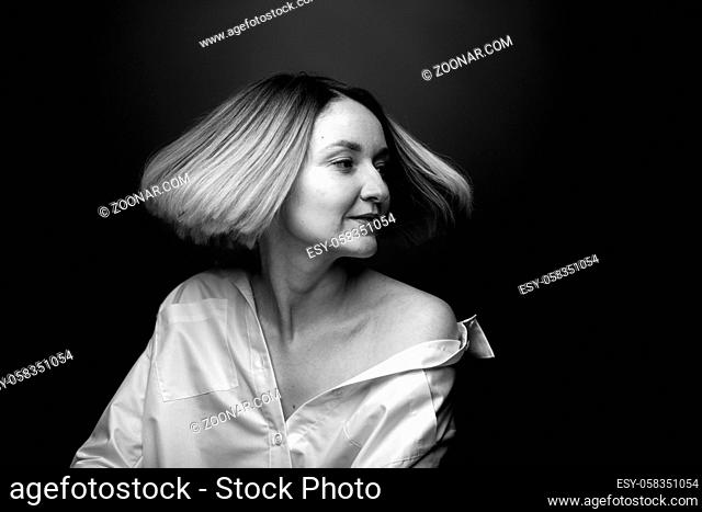 Dramatic black and white portrait of a beautiful woman on a dark background, studio shoot. Concept of natural beauty, no retouch