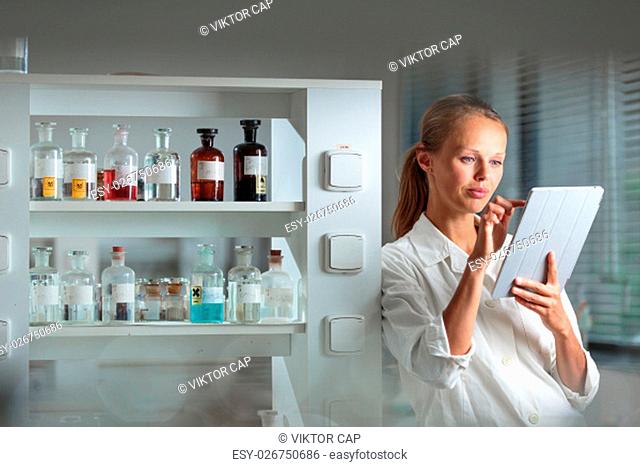Portrait of a female researcher doing research in a biochemistry lab (shallow DOF; color toned image)