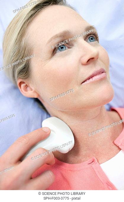 Ultrasound scan. Woman having an ultrasound scan of her neck