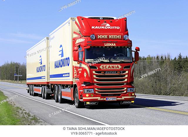 Red Super Scania refrigerated transport truck for Kaukokiito Oy at speed on highway on a clear day of spring in Forssa, Finland - May 11, 2018.