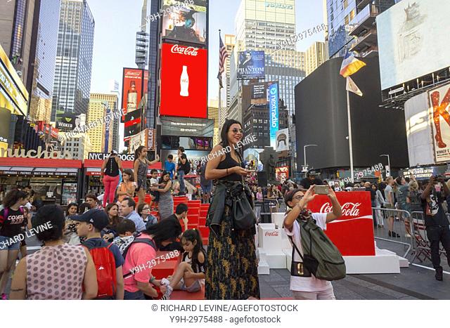 Throngs of tourists pose for selfies in Times Square in New York on the unveiling of the newest iteration of Coca-Cola's digital sign on Tuesday, August 8, 2017