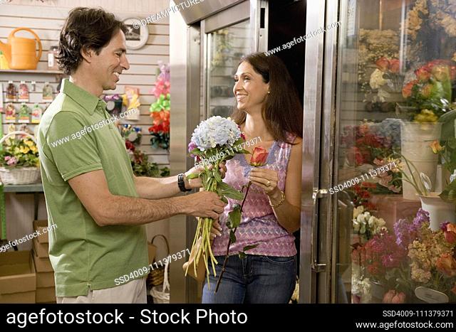 Hispanic couple looking at flowers in florist shop