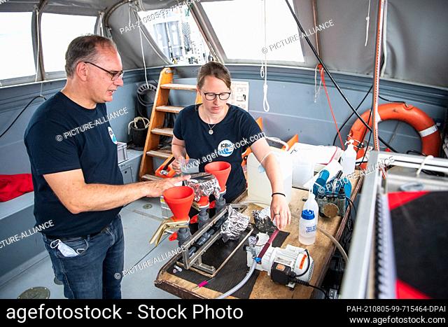 PRODUCTION - 22 July 2021, Lower Saxony, Nordsee: Thomas Badewien and Claudia Thölen, from the University of Oldenburg, work on the processing of water samples...