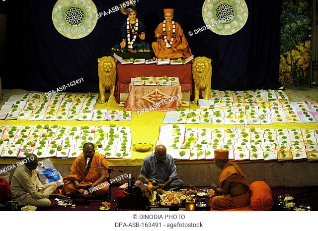 Swaminarayan priests performing chopadi puja ritual performed on lakshmi puja ; Bombay Mumbai ; Maharashtra ; India