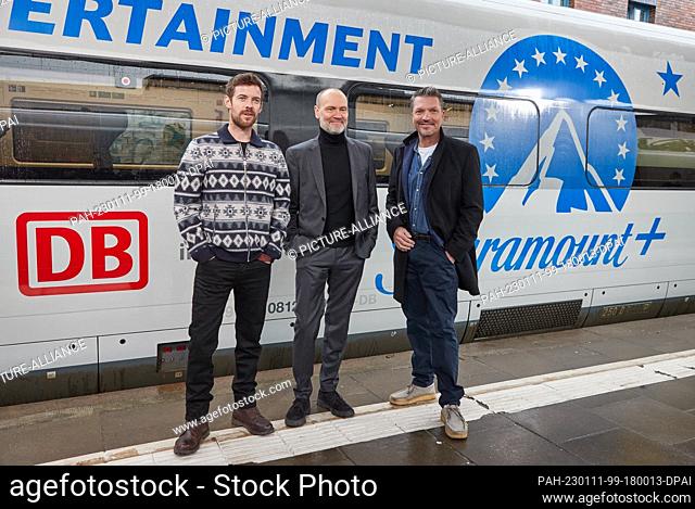 11 January 2023, Hamburg: Harry Treadaway (l-r), actor, Simon Beckett, author, and Hardy Krüger Jr., actor, stand on a platform at Altona station during a press...