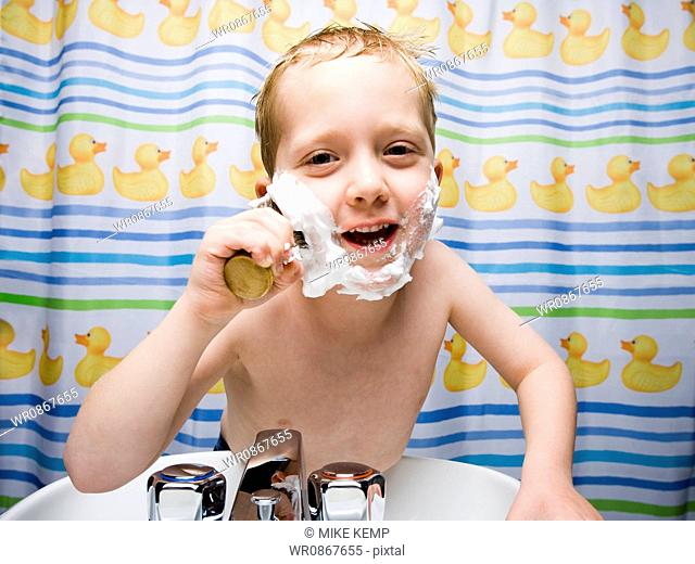 Boy shaving in bathroom