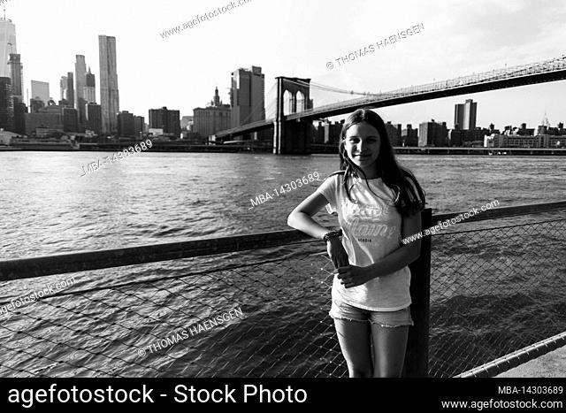 Dumbo/FULTON FERRY, New York City, NY, USA, Two kids in front of the Brooklyn Bridge over East River 14 years old, caucasian teenager girl with brown hair in...