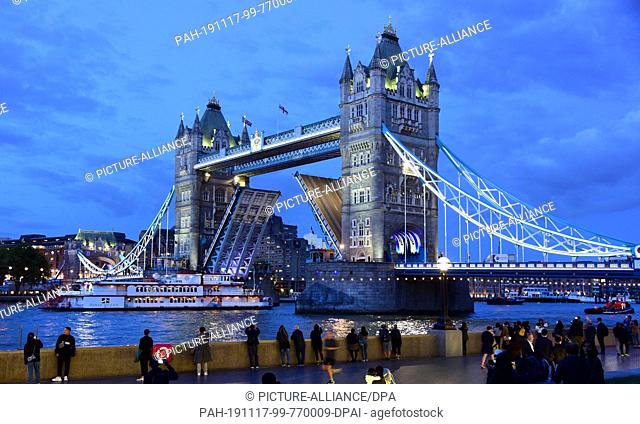 05 September 2019, Great Britain, London: The Tower Bridge over the Thames in the evening hours. Both halves of the bridge are open for the passage of a larger...