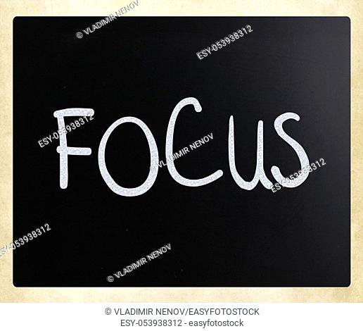 The word ""Focus"" handwritten with white chalk on a blackboard