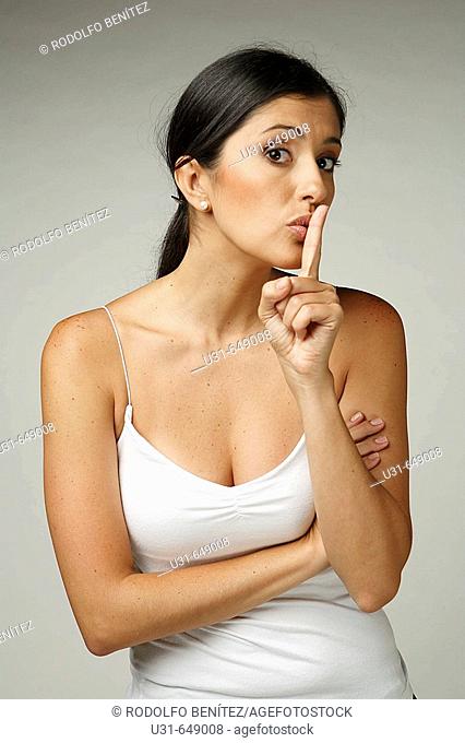 Beautiful Latin woman signals to be quiet