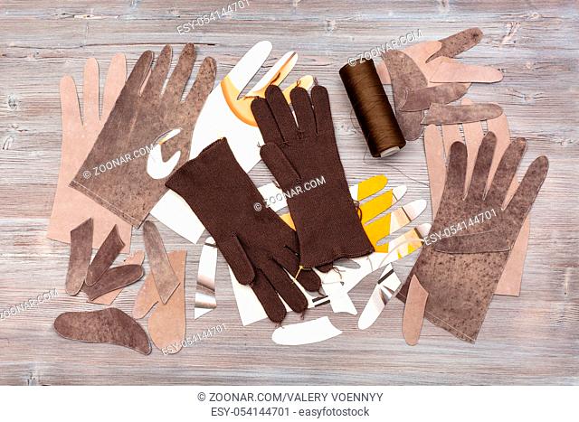 workshop on sewing gloves - top view of various details for gloves production on wooden background