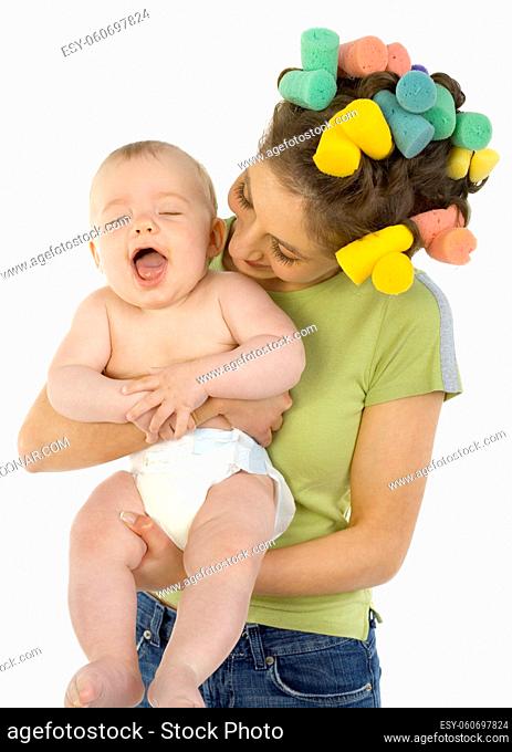 Young, beautiful woman with baby on hands. Hugging baby and smiling. Baby is laughing, white background. Front view