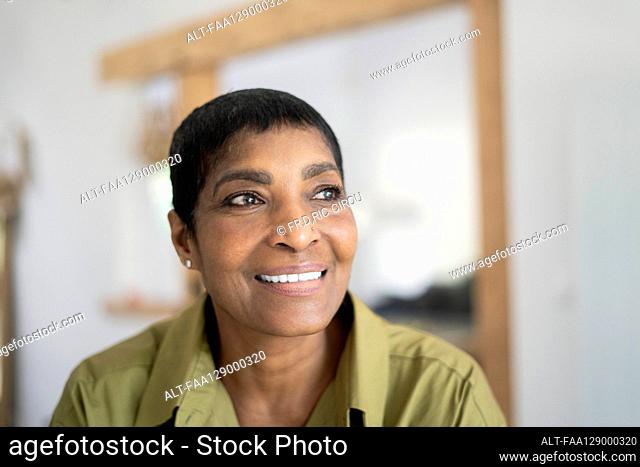 Smiling mature woman sitting in living room