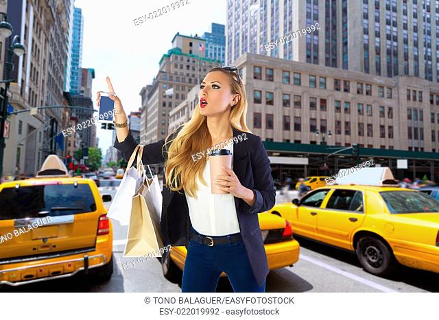 Blond shopping tourist girl calling a yellow Taxi in New York fifth avenue Photomount
