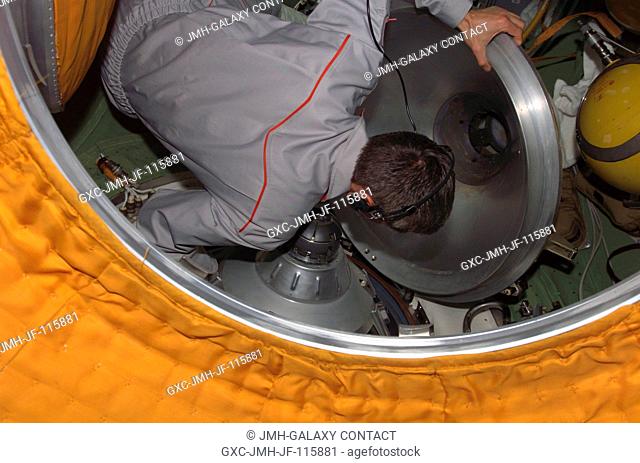 Cosmonaut Sergei K. Krikalev, Expedition 11 commander representing Russia's Federal Space Agency, closes the hatch to the Soyuz TMA-5 spacecraft docked to the...