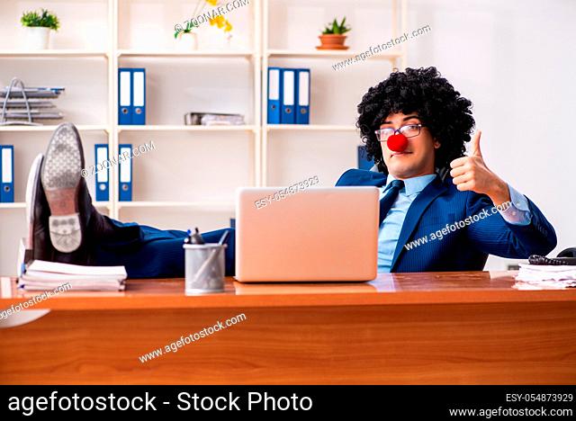 Young clown businessman working in the office