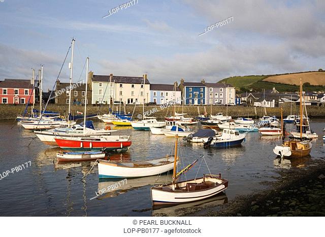Wales, Ceredigion, Aberaeron, View across Aberaeron harbour with boats moored and colourful Georgian houses reflected in the Afon Aeron river