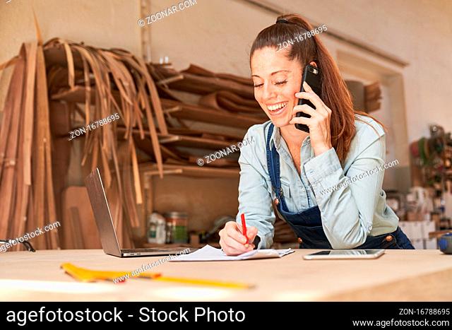 Junge Handwerker Frau mit Handy im Kundenservice oder bei der Terminplanung