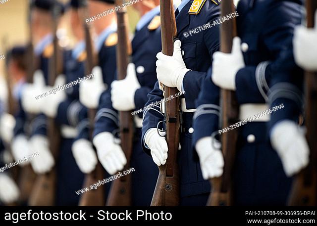 08 July 2021, North Rhine-Westphalia, Rheine: Soldiers present their rifle on the roll call square on the grounds of the Bundeswehr barracks
