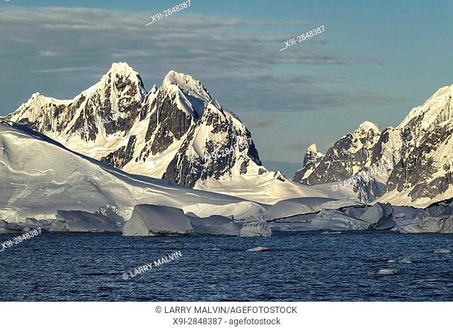 Jagged mountains, glaciers and foreground icebergs along the Antarctic Peninsula