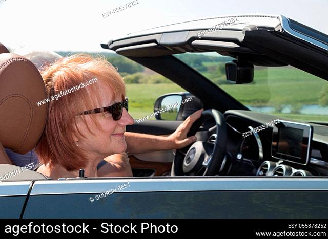 Smiling happy senior couple in sports car