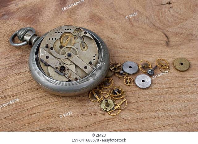 broken vintage pocket watch on wooden background