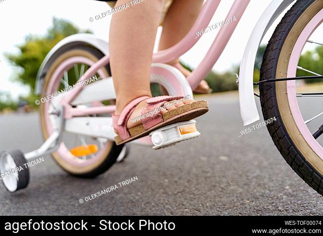 Girl riding bicycle on road