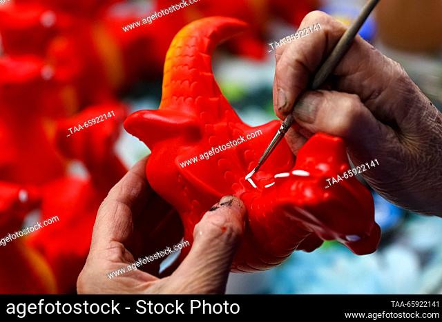 RUSSIA, VORONEZH - DECEMBER 19, 2023: An employee paints a Christmas ornament at the Igrushki factory. The enterprise is engaged in production of PVC plastisol...