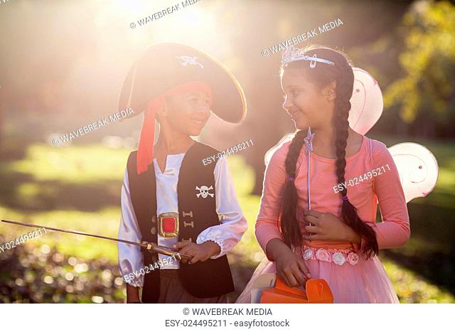 Smiling siblings wearing costumes at park