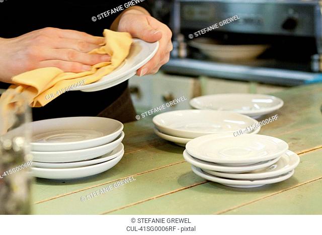 Hands drying dishes in kitchen