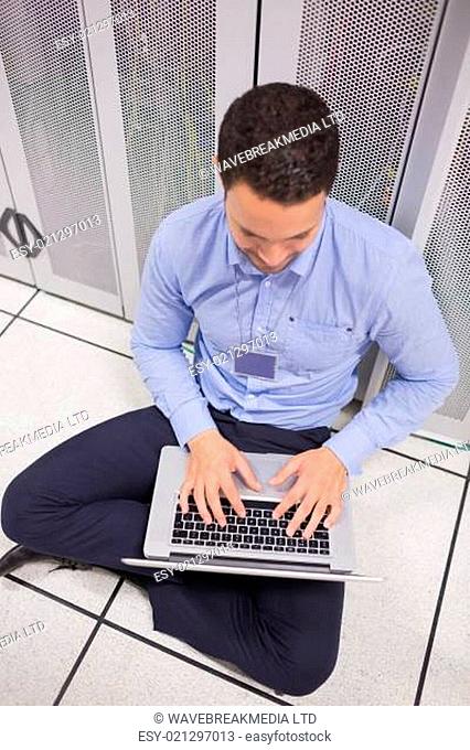 Man using his laptop in data center in front of servers