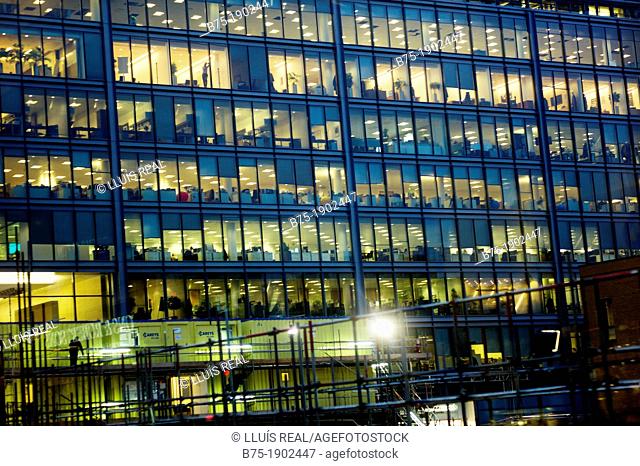 office building with many windows, at night with lights on