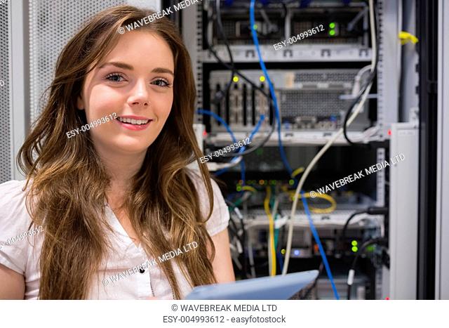 Smiling woman standing in front of servers in data storage