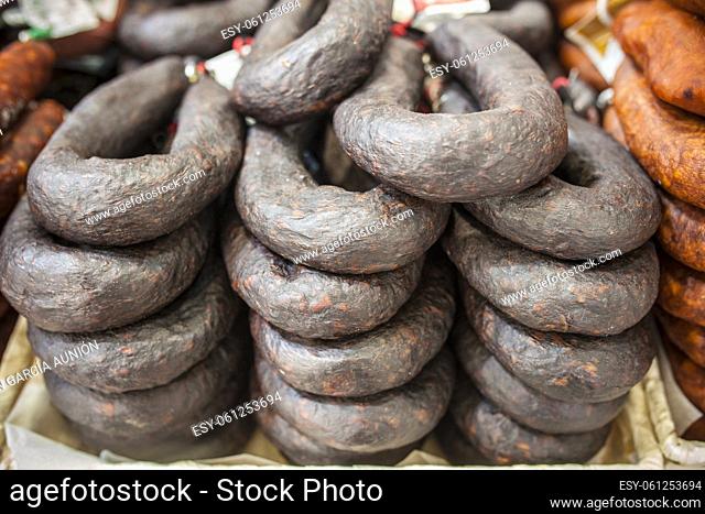 Black sausage or black iberian morcilla pile displayed at street market stall. Closeup